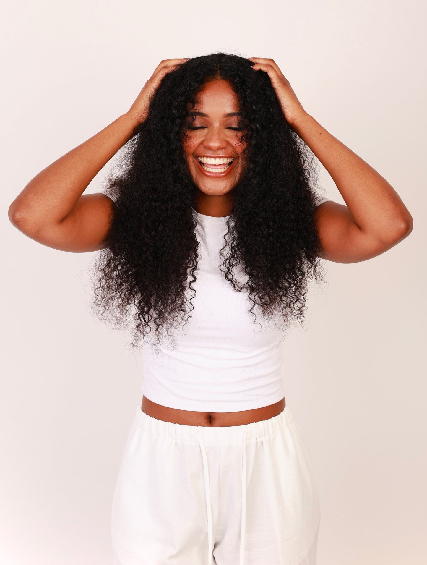 Model wearing thick and full bundles of deep curly hair 