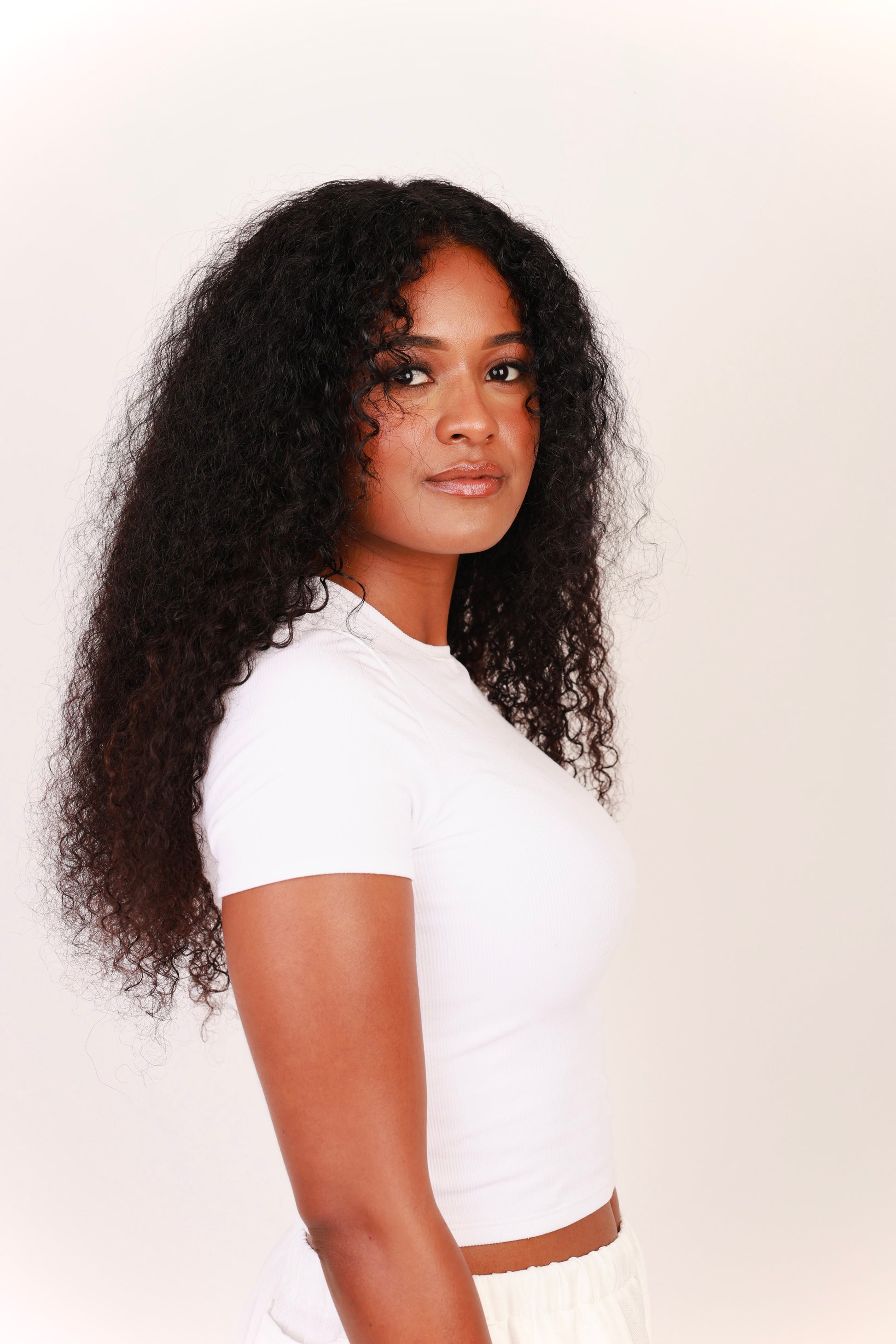 Side view of model wearing 20 inch deep curly hair extensions 